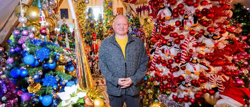 Thomas Jeromin steht inmitten von Weihnachtsbäumen in seinem Haus im Landkreis Schaumburg.