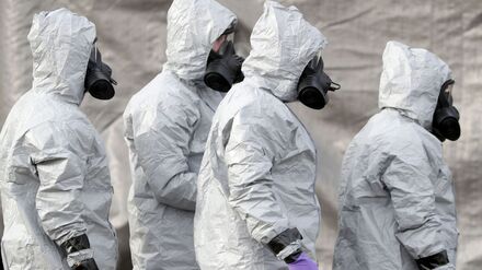 Ermittler in Schutzkleidung und Gasmasken bereiten den Abtransport eines Krankenwagens an einer Station des Sanitätsdienstleisters South Western Ambulance Service in der Nähe von Salisbury vor.