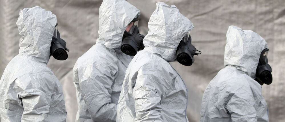 Ermittler in Schutzkleidung und Gasmasken bereiten den Abtransport eines Krankenwagens an einer Station des Sanitätsdienstleisters South Western Ambulance Service in der Nähe von Salisbury vor. 