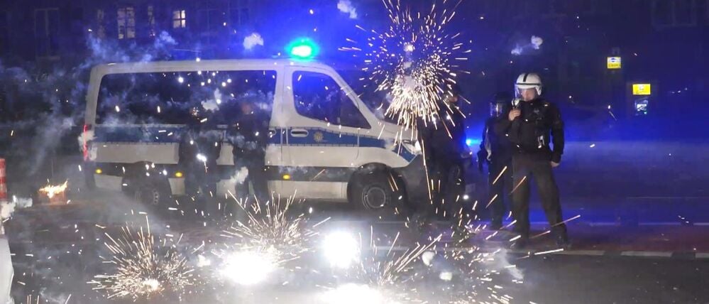 Berlin: Polizeibeamte stehen am Silvesterabend hinter explodierendem Feuerwerk. (Archivbild)