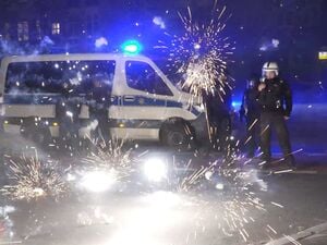 Berlin: Polizeibeamte stehen am Silvesterabend hinter explodierendem Feuerwerk. (Archivbild)