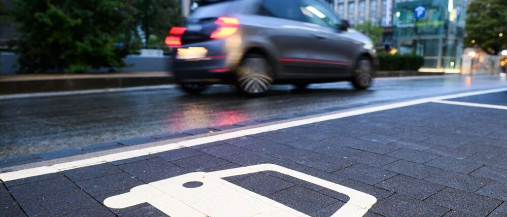 Ein Symbol markiert einen Parkplatz an einer Ladesäule für Elektroautos.