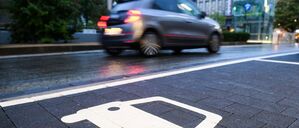 Ein Symbol markiert einen Parkplatz an einer Ladesäule für Elektroautos.