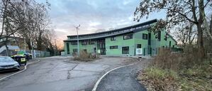 Jugendclub Wildwuchs in Berlin Spandau, fehlende Straße vor dem Neubau - Kunst am Bau (das Windrad mit Stein und Wasser).