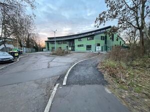Jugendclub Wildwuchs in Berlin Spandau, fehlende Straße vor dem Neubau - Kunst am Bau (das Windrad mit Stein und Wasser).