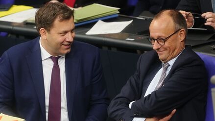 Lars Klingbeil (SPD, l), Bundesminister der Finanzen, spricht mit Bundeskanzler Friedrich Merz (CDU) während der Sitzung des Bundestags. Thema ist die Rentenreform. 