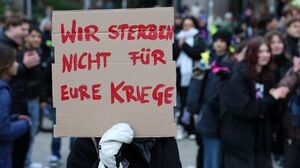 Eine Teilnehmerin hält eine Botschaft in die Kamera.