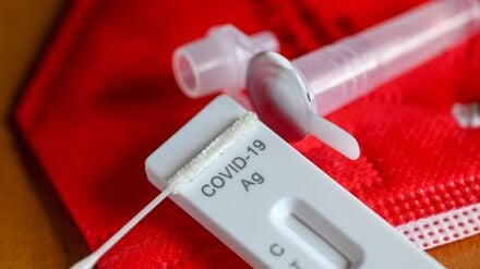 Ein Antigentest zum Nachweis von Covid-19 zum Selbsttest liegt auf einer roten FFP-2-Maske.