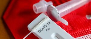 Ein Antigentest zum Nachweis von Covid-19 zum Selbsttest liegt auf einer roten FFP-2-Maske.