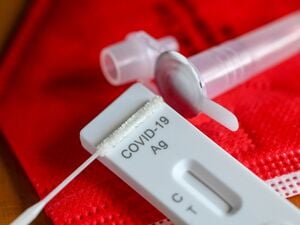 Ein Antigentest zum Nachweis von Covid-19 zum Selbsttest liegt auf einer roten FFP-2-Maske.