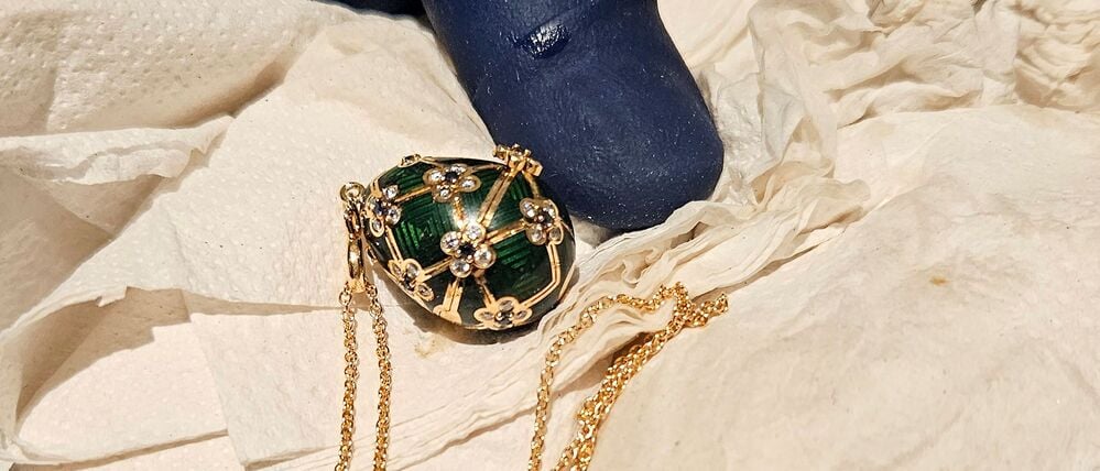 Ein neuseeländischer Polizeibeamter präsentiert ein mit Diamanten besetztes grünes Fabergé-Ei.