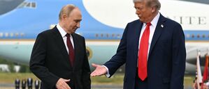 US-Präsident Donald Trump (rechts) streckt seine Hand aus, um dem russischen Präsidenten Wladimir Putin die Hand zu schütteln, während sie nach ihrer Ankunft auf der Joint Base Elmendorf-Richardson in Anchorage, Alaska, am 15. August 2025 auf einem Podium auf dem Rollfeld posieren. 