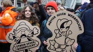Zwei Jugendliche halten Plakate beim Schulstreik gegen die Wehrpflicht in den Händen.