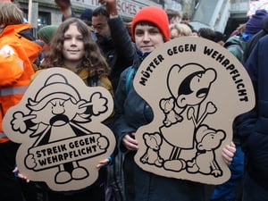 Zwei Jugendliche halten Plakate beim Schulstreik gegen die Wehrpflicht in den Händen.