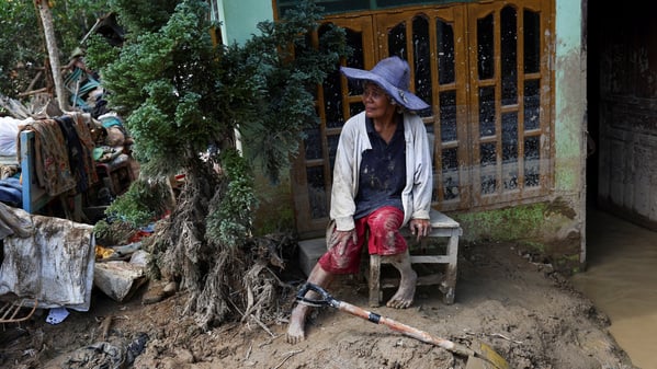 Survivor Rismawati Simanjuntak, 63, sits as she takes a break while collecting valuable goods and cleaning her house following deadly flash flood in Batang Toru, South Tapanuli, North Sumatra province, Indonesia, December 6, 2025. REUTERS/Willy Kurniawan