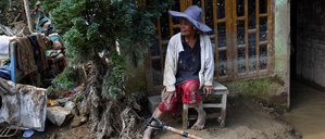 Survivor Rismawati Simanjuntak, 63, sits as she takes a break while collecting valuable goods and cleaning her house following deadly flash flood in Batang Toru, South Tapanuli, North Sumatra province, Indonesia, December 6, 2025. REUTERS/Willy Kurniawan