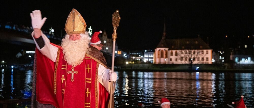 Von zahlreichen Fackelschwimmern begleitet ist der Nikolaus in Bernkastel-Kues in einem Ruderboot über die Mosel gekommen.
