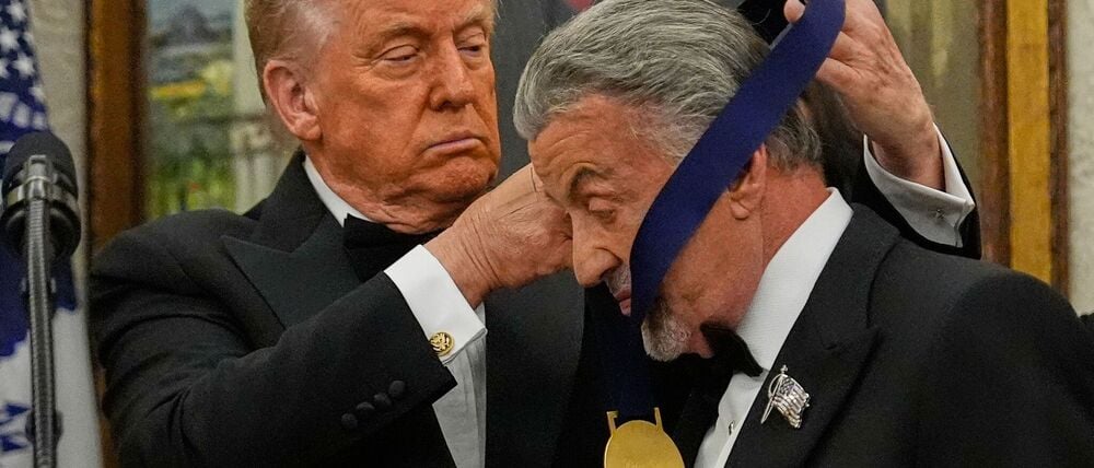 US-Präsident Donald Trump hängt der Actionfilm-Ikone Sylvester Stallone eine Medaille um.