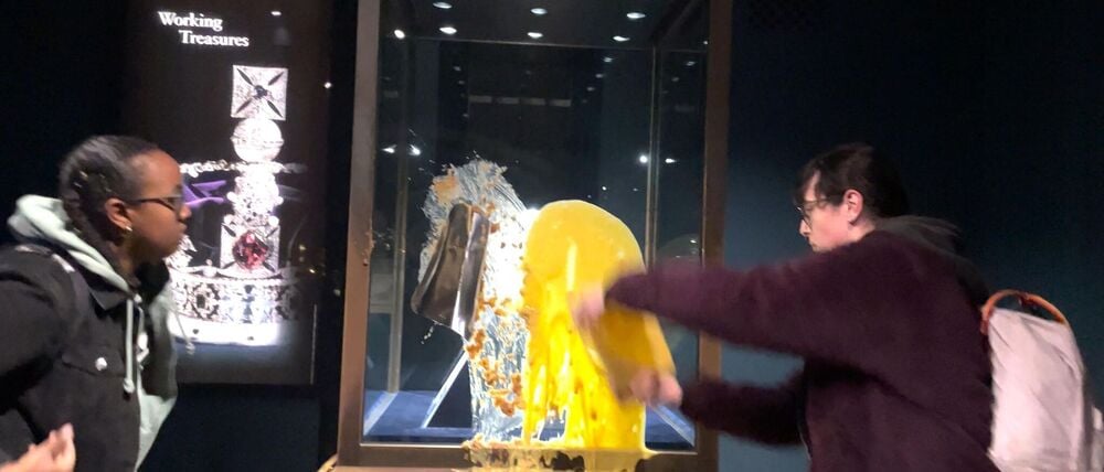 Aktivisten beschmieren die Vitrine, in der die Krone ist.