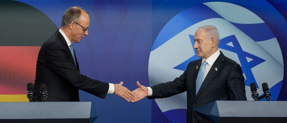 Bundeskanzler Friedrich Merz schüttelt bei einer Pressekonferenz in Israel die Hand von Benjamin Netanjahu.