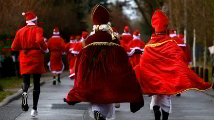 People dressed as Santa Claus and St. Nicholas run through the streets as they take part in the annual 'Nikolauslauf' in Michendorf, Germany, December 7, 2025. REUTERS/Lisi Niesner
