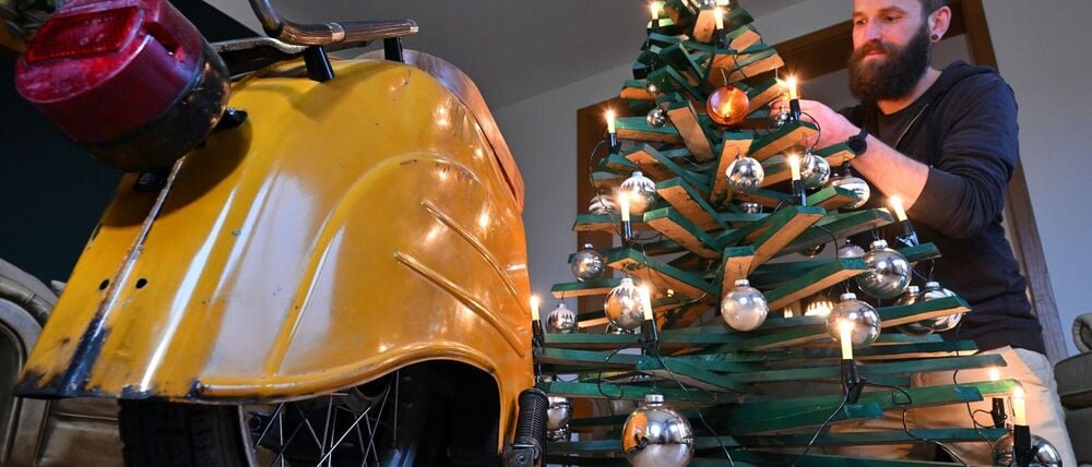 Jan Hofmann schmückt einen Weihnachtsbaum auch mit Weihnachtsbaumkugeln aus Simson-Blinkern.