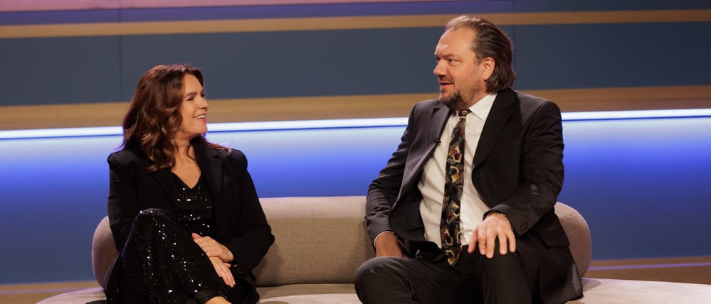 Vom Bademantel-Schluffi zum TV-Promi: Charly Hübner als „Der Held vom Bahnhof Friedrichstraße“ neben Kati Witt.
