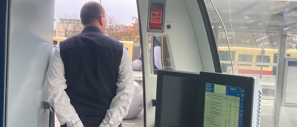 Stefan Lemke macht per Mikrofon eine Ansage, während die Fahrgäste einsteigen.