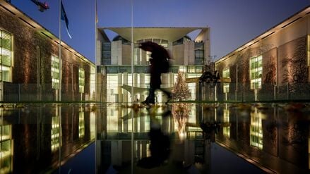 Passanten gehen am Morgen im Regen vor der Abstimmung im Bundestag über das Rentenpaket der Koalition am Bundeskanzleramt vorbei.