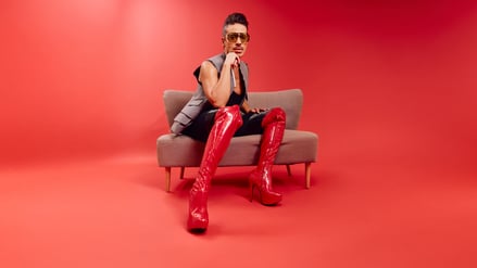 Jorge González in roten Overknees aus Leder.