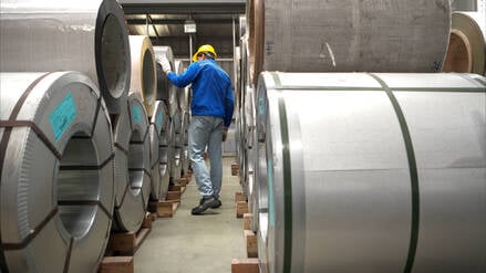 Industriearbeiter bei der Inspektion eines großen Metallrohrs in einer Fabrik (Symbolbild).