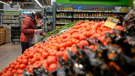 Eine Frau packt sich Gemüse in einem Supermarkt in Russland zusammen.