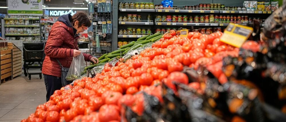 Eine Frau packt sich Gemüse in einem Supermarkt in Russland zusammen.
