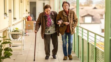 Mit der Hilfe der Tochter: Eine Seniorin ist außerhalb der eigenen vier Wände mit Unterstützung unterwegs.