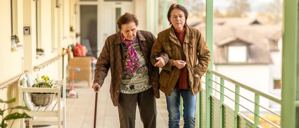 Mit der Hilfe der Tochter: Eine Seniorin ist außerhalb der eigenen vier Wände mit Unterstützung unterwegs.