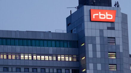 Das beleuchtete Logo des Senders Rundfunk Berlin-Brandenburg (RBB) ist an der Fassade am Sitz des Senders an der Masurenallee angebracht.