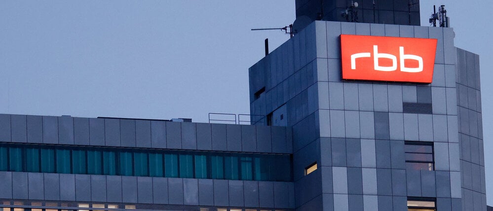 Das beleuchtete Logo des Senders Rundfunk Berlin-Brandenburg (RBB) ist an der Fassade am Sitz des Senders an der Masurenallee angebracht.