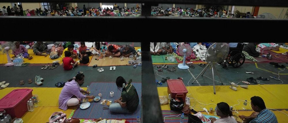 Thailändische Einwohner, die nach den Zusammenstößen zwischen thailändischen und kambodschanischen Soldaten aus ihren Häusern geflohen sind, ruhen sich in einem Evakuierungszentrum in der thailändischen Provinz Surin aus.