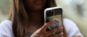 Ein Teenager hält in Sydney ihr Handy in der Hand.