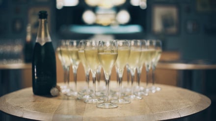 Champagnergläser samt -flasche stehen auf einem Tisch.