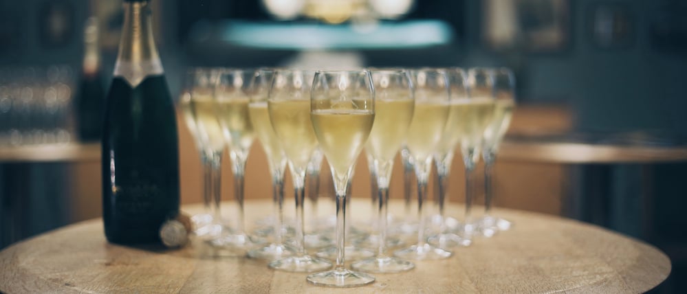 Champagnergläser samt -flasche stehen auf einem Tisch.