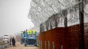 Arbeiter befestigen Stacheldraht am Zaun entlang der ungarischen Grenze zu Serbien.