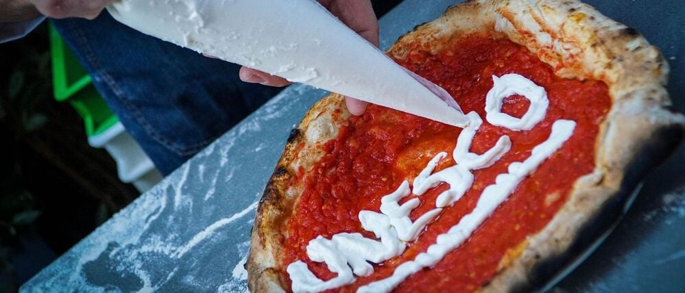 Ein Pizzabäcker schreibt den Schriftzug „Unesco“ auf eine Pizza. Italiens Regierung rührt die Werbetrommel für die «cucina italiana».