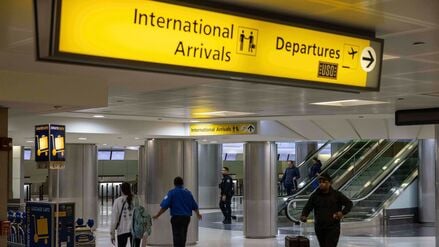 Menschen mit Koffern gehen durch das internationale Terminal des Newark Liberty International Airport.