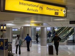 Menschen mit Koffern gehen durch das internationale Terminal des Newark Liberty International Airport.
