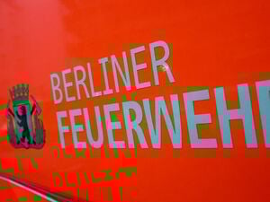 Der Schriftzug „Berliner Feuerwehr“ und das Wappen Berliner Feuerwehr mit dem Berliner Bären stehen auf der Tür eines Feuerwehrfahrzeuges. (Symbolbild)