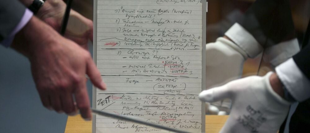 Mitarbeiter stülpen im Haus der Geschichte eine Glasvitrine über den Schabowski-Zettel. Um das Ausstellungsstück gibt es seit Jahren Streit mit einem Journalisten. (Archivbild)