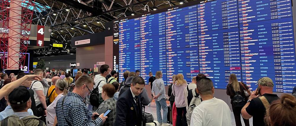 Passagiere überprüfen eine Flugtafel am internationalen Flughafen Sheremetyevo außerhalb von Moskau (Symbolbild).