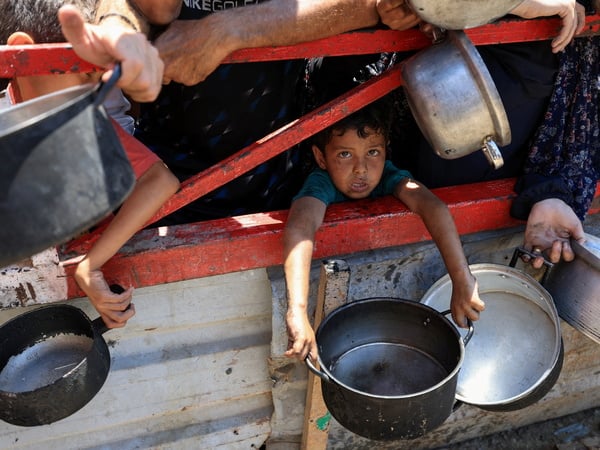 A child holds a pot as Palestinians gather to receive food from a charity kitchen, amid a hunger crisis, in Gaza City, July 22, 2025. REUTERS/Dawoud Abu Alkas     TPX IMAGES OF THE DAY     