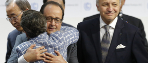 Der damalige französische Präsident François Hollande umarmt nach der Annahme des Abkommens Christiana Figueres von der Klimarahmenkonvention der Vereinten Nationen. Der damalige französische Außenminister Laurent Fabius (rechts) hatte die Verhandlungen in Paris geleitet.